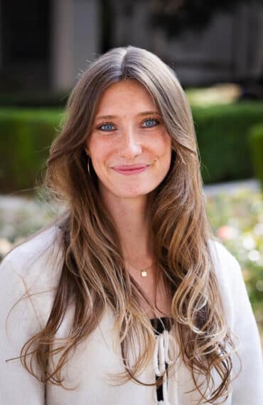 Julia Wilson, MA, smiling outdoors in a cream cardigan, a HERE Counseling therapist in Pasadena.